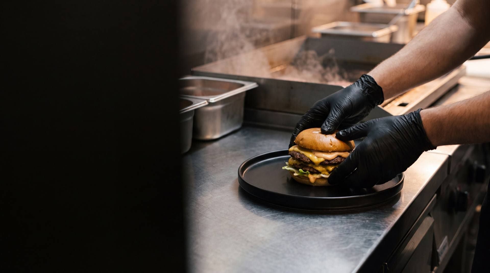 Kuhar slaže smash burger na tanjur